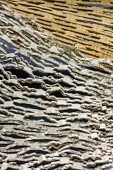 Textured surface of layered cardboard showcasing intricate patterns and shadows in an artistic display, ideal for design inspiration and material studies