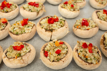 Stuffed champignon mushrooms with rice, parsley and pepper on a sheet of baking paper