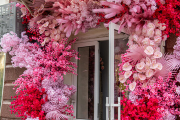 Decorating the entrance group of a store or cafe with artificial plants. Pink and flowers. Flowers...