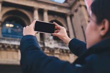 Unrecognizable woman tourist taking photos of old cathedral