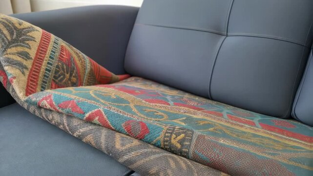 A closeup of a wornout colorful textile being unraveled as its rep with a modern durable fabric for upholstered seating highlighting an upgrade in comfort.