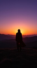 Obraz premium Silhouette of a woman overlooking a sunset-drenched mountain range, capturing a moment of solitude and awe at nature's beauty.