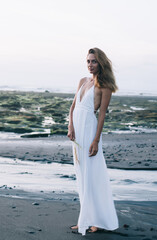 Slim woman standing on sand beach
