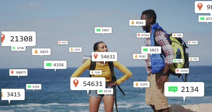Two backpackers exploring cliff by ocean, showing floating notification icons for travel tech