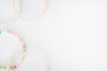 Top view of colorful beaded bracelets arranged in a corner on a clean white background