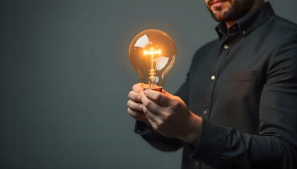 Partial view of man holding bulb on grey background