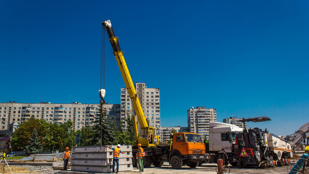 Unloading concrete plates by crane at road construction site timelapse.