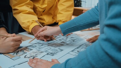 A collaborative scene featuring diverse designers intensely analyzing architectural blueprints and sketches in a dynamic workspace, full of creativity and innovation. SACTR