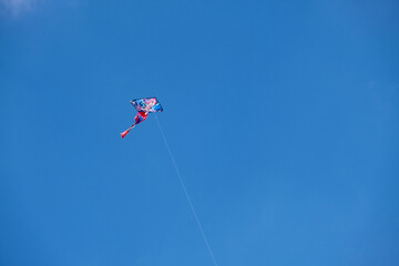colorful kite flying high in the blue sky.