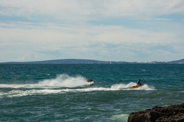 Jet skis in the Mediterranean Sea, on a sunny day with a cloudy sky