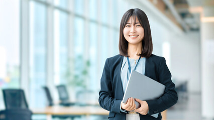 ノートパソコンを持つ笑顔の女性・ビジネスウーマン