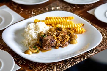 Luxurious and exquisite dish, filet mignon with mushroom sauce accompanied by white rice and French fries. Filet mignon with rust sauce