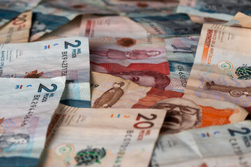 Fototapeta premium Pile of Mixed Colombian Bills Spread on a Table