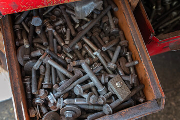 Mechanic tools, nuts and bolts filling a drawer in a workshop