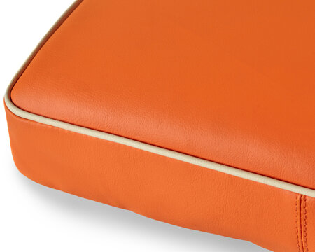 Close up of orange leather upholstery with cream piping detailing