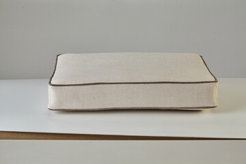 Beige meditation cushion resting on white surface promoting relaxation and mindfulness