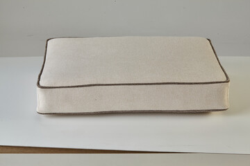Comfortable white rectangular cushion resting on white surface
