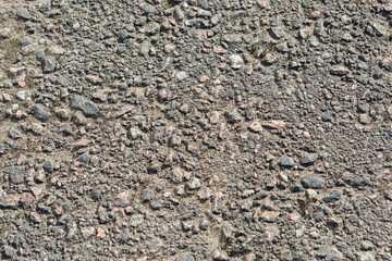 The texture of the asphalt surface, the background is gray asphalt. Rough stone surface of the road.
