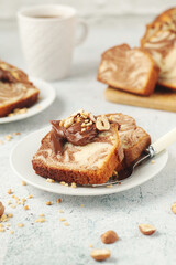 A piece of marble biscuit with chocolate cream and nuts