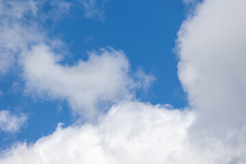 Obraz premium White clouds drifting across vibrant blue sky