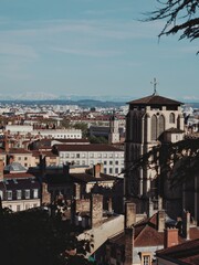 Classic city skyline with mountains and sunny sky in the background.