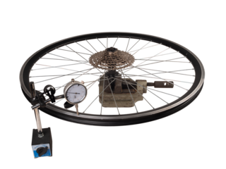 Checking a bicycle wheel with a dial gauge. Isolated background.