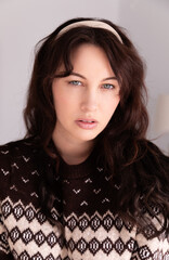 Close-up portrait of a 30-year-old Canadian caucasian woman wearing a vintage brown sweater and...