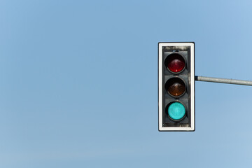 Green light on traffic lights. Isolated on blue background. Negative copy space for placement of...
