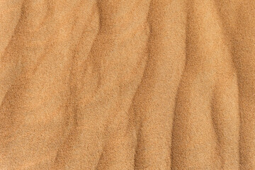 Close-up  background sand wave with rippled dunes. Top view. Space for text. Sand summer texture.