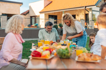 Family enjoying a healthy lunch together in the backyard
