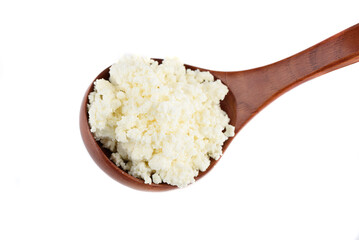 Wooden spoon with fresh cottage cheese isolated on white background.