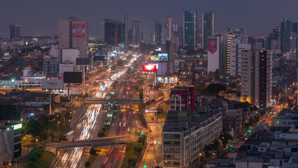 Aerial view of Via Expresa highway and metropolitan bus with traffic day to night timelapse. Lima, Peru
