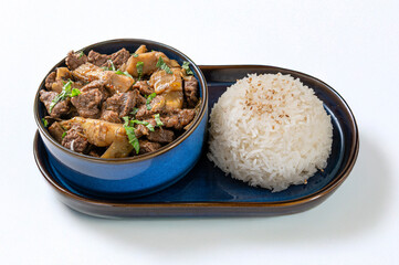 Phuket beef dish with artichokes, Thai spices and basil, served with white rice in blue ceramic bowls. Bright and inviting photo, perfect for Asian and traditional Thai cuisine themes.