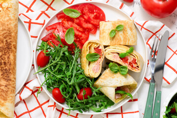 Tortilla roll with omelet, ham, cheese and tomato.top veiw