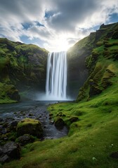 Fototapeta premium Majestic Icelandic waterfall cascading through lush green landscape under brilliant sky with scattered clouds creating ethereal beauty, inspiring tranquility