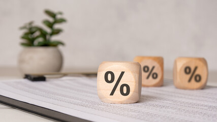 Wooden blocks with percent signs on financial documents