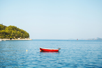 A Serene Red Boat Float Gracefully on Calm Waters Surrounded by Natures Beauty and Peace