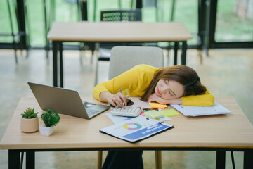 Asian businesswoman at desk feeling headache while sleeping. Tired Asian woman.