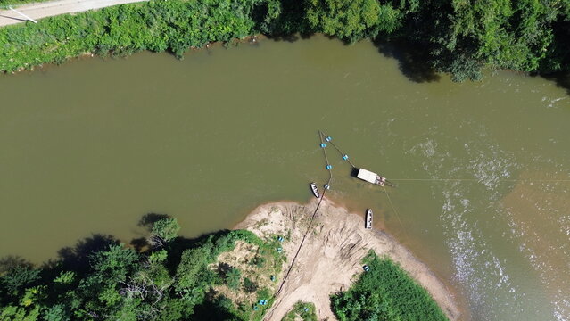A extra&ccedil;&atilde;o de areia em leito ativo de um rio com uso de draga instalada em uma balsa, vista com uso de drone.