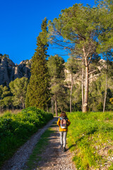 Tourist walking on a path near montserrat mountains on a sunny day