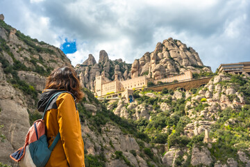 Tourist enjoying the view of santa maria de montserrat abbey in the montserrat mountains,...