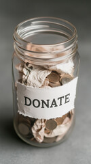 Collecting donations in a glass jar filled with coins and crumpled bills on a neutral background