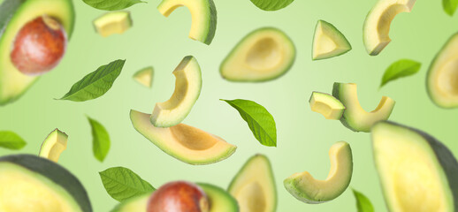 Fresh avocado fruits with leaves flying on light green background. Banner design