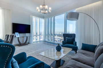 Incomparable panoramic view from the living room. Stylish sofas and armchairs, a large TV.