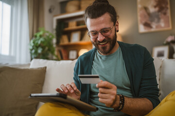 online shopping man hold credit or debit card make purchase at home