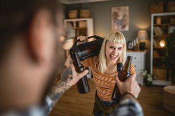 Adult woman sing karaoke on microphone and man hold bottle of beer