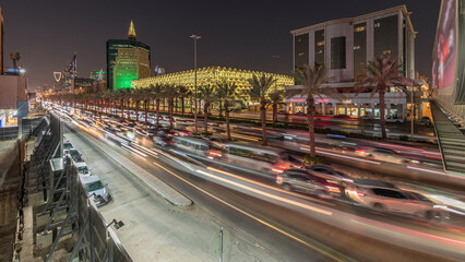 Aerial day to night timelapse of King Fahd Road near the illuminated Riyadh National Library in...