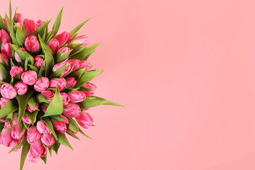 Naklejka premium Bouquet of beautiful tulips on pink background, top view. Space for text