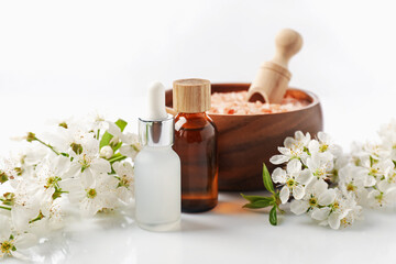 Spa composition with cosmetic products and beautiful flowers on white background, closeup