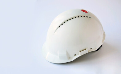 Fototapeta premium White helmet used by civil engineers on white surface with copy space